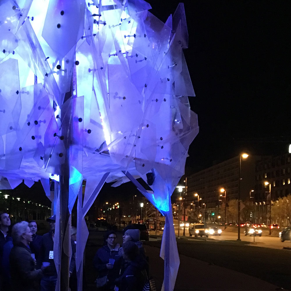 Finished Glacier sculpture illuminated at night with crowd watching