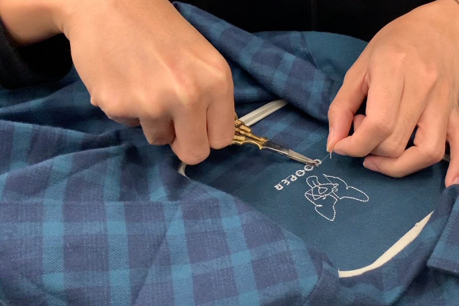 Hand-embroidering Cooper the Corgi onto a shirt